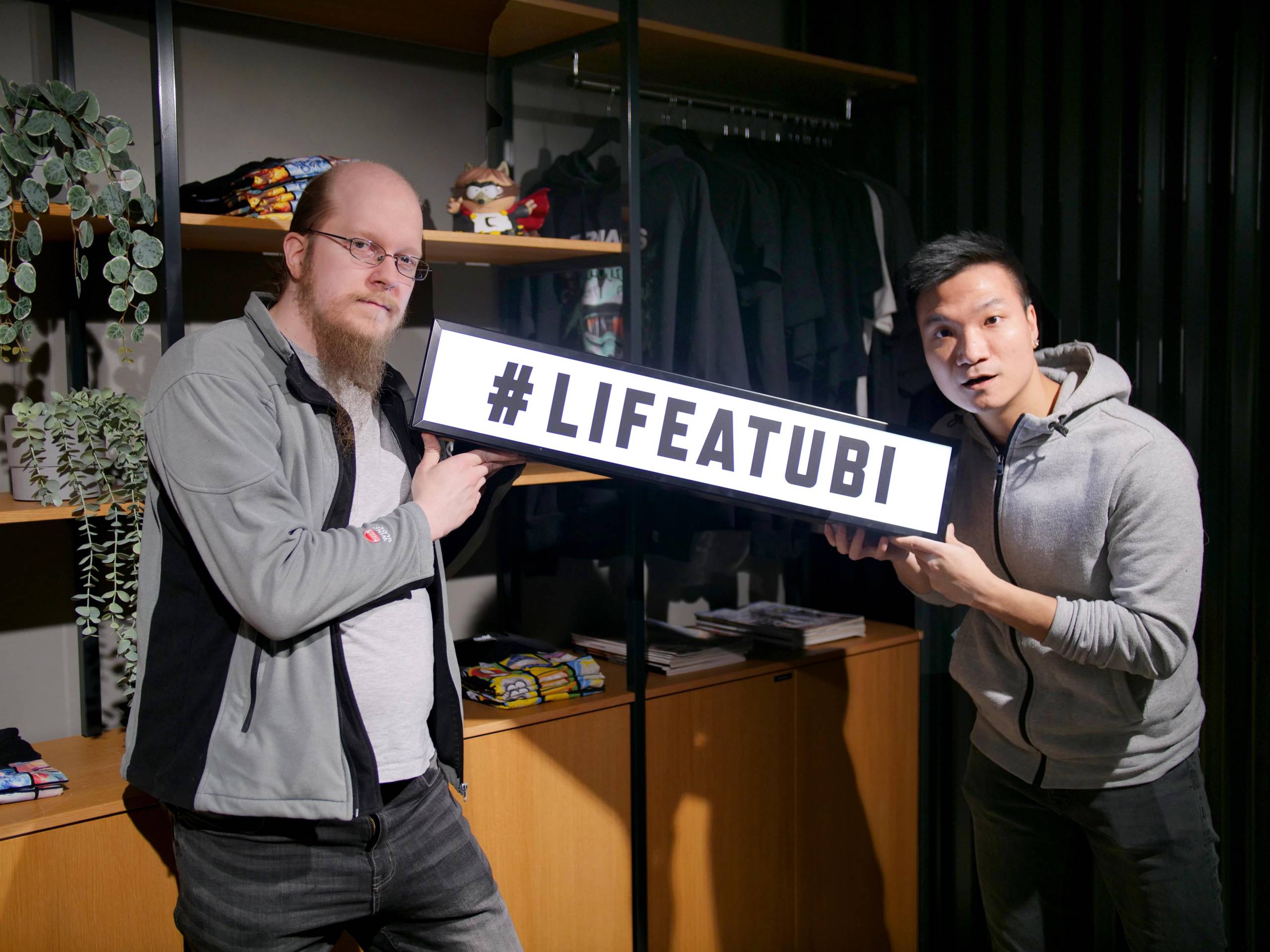 Two team members holding a placate with a Life at Ubi hashtag.